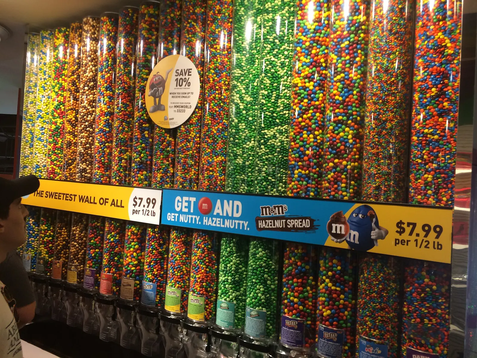 Corredor curvo com tubos de M&M's coloridos na loja de Nova York.